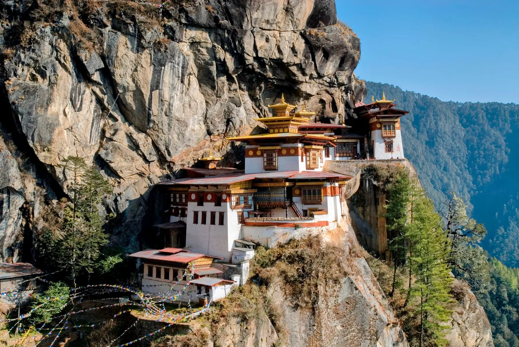 The monastery with prayer flags along the cliff path