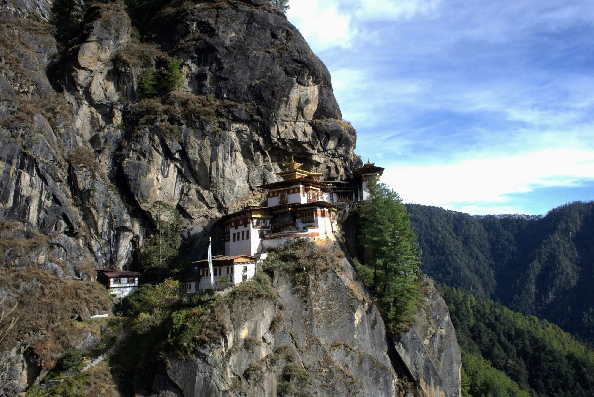 Temple buildings tucked beneath the cliff overhang